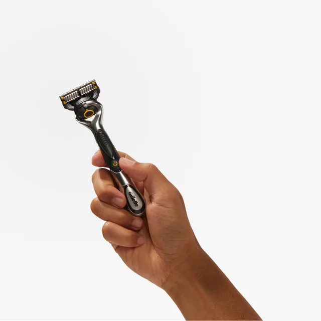 Gillette multi-blade razor held firmly in a hand, highlighting its design.